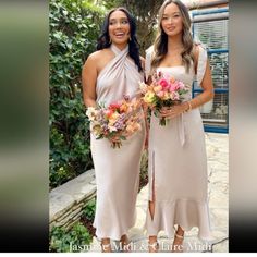 two beautiful women standing next to each other holding bouquets in their hands and smiling at the camera