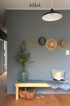 there is a bench in the room with hats on the wall