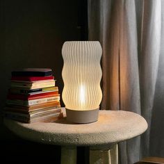 a lamp sitting on top of a table next to books