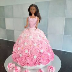 a doll is sitting on top of a pink dress made out of cupcakes