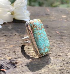 Gorgeous American Super Nova turquoise from Nevada set in a handmade ring I fabricated out of sterling silver. I am in love with rectangular stones, and this big beauty captivated me from the beginning. It's a thick cut stone so it has quite a lovely presence on the ring. The sterling silver band features two separate rings of sterling silver parallel side by side. This is one of my favorite ring band designs to make. The turquoise is a rich aqua color with a light warm brown matrix. The ring face measures just over 1.25 inches tall. Comfortably fits a size 8.25 to an 8.5. I list the size variation, because it depends on which way you wear the ring. It's slightly tighter in one direction than the other. Signed ghostdog 925. Polished to a glowing satin finish. Rectangular Turquoise Gemstone Ring, Artisan Turquoise Rectangular Jewelry, Unique Rectangular Gemstone Ring, Rectangular Turquoise Ring Gift, Handmade Turquoise Rectangular Rings, Bohemian Turquoise Rectangular Jewelry, Bohemian Sterling Silver Ring With Rectangular Shape, Rectangular Turquoise Ring For Anniversary, Rectangular Turquoise Rings For Anniversary