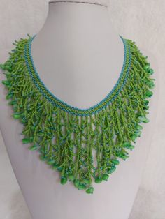 Embrace the enchanting allure of my 'Tropical Breeze Green & Turquoise Harmony Seed Bead Branching Waterfall' necklace! Handcrafted with love, this mesmerizing piece boasts a cascade of vibrant green and turquoise seed beads complemented by green stone chips, creating a stunning visual symphony. Each bead is meticulously threaded with quality beading thread, ensuring durability and lasting beauty. The necklace is adorned with a gold-plated lobster clasp and an extension chain, allowing a customizable length of 47 cm. At its longest drop, it gracefully extends 18 cm, adding a touch of elegance to any ensemble. Elevate your style with this radiant, nature-inspired creation. Bohemian Bib Necklace With Polished Beads As Gift, Green Turquoise Necklace With Round Beads For Beach, Handmade Dangle Beaded Necklaces For Beach, Handmade Bohemian Drop Necklace, Bohemian Beaded Drop Necklace As Gift, Bohemian Green Handmade Turquoise Necklace, Bohemian Beaded Drop Necklace For Gift, Bohemian Beaded Necklaces For Beach With Polished Beads, Bohemian Green Turquoise Necklace For Jewelry Making