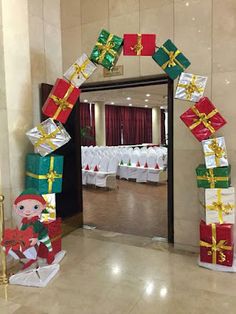 an archway decorated with christmas presents and decorations for a wedding or other function in a hotel lobby