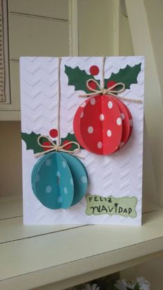 a card with two christmas ornaments hanging from it