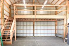 an empty garage with stairs leading up to the second floor and storage doors on both sides