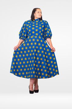 Take joy in each spin with the vibrant Camille Puff Sleeve Dress, in a beautiful blue shade that reflects the sky's brightness. This puff sleeve designer dress is perfect for casual afternoon hangouts, elegant weddings, memorable events, and spectacular nights out. With its short puff sleeves, midi length, it offers a blend of classic charm and modern appeal. Flared fit  Shaped neckline and waistline Easy zip closure  Midi-length Two in-seam pockets 100% Cotton Handmade in the UK Model is 5 ft 6 Blue Floral Print Puff Sleeve Midi Dress, Blue Floral Print Midi Length Puff Sleeve Dress, Blue Fitted Puff Sleeve Dress With Short Sleeves, Light Blue Fitted Midi Dress With Puff Sleeves, Blue Ankara Dress, Blue Ankara, Angel Sleeves Dress, African Print Skirt, African Print Clothing