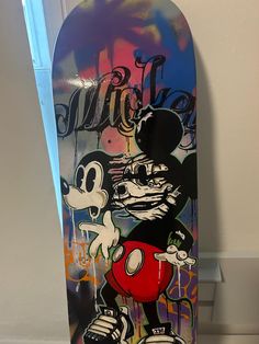 a skateboard with an image of mickey mouse painted on it's bottom half