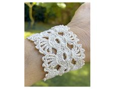 a white crocheted bracelet on someone's arm