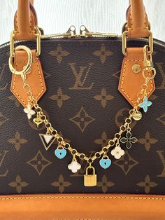 a brown louis vuitton bag with charms on it