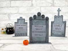 three tombstones with headstones on them and a pumpkin in the foreground next to them