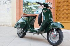 a green scooter parked in front of a building