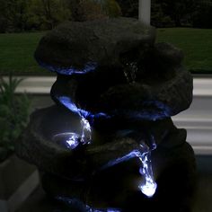 an outdoor fountain with blue lights on it