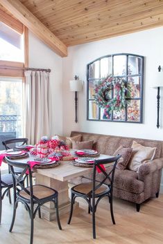 a living room filled with furniture and a wooden table topped with plates on top of it