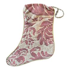 a pink and white stocking with an ornate design on the front, hanging from a cord