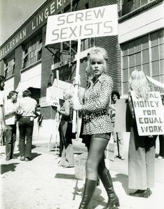 an old black and white photo of a woman holding a sign that says screw sexists