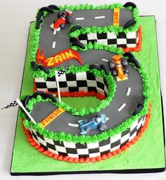 a cake shaped like a race track with cars on it