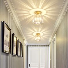 the hallway is decorated in white and has two chandeliers