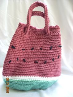 a crocheted watermelon purse sitting on top of a white tablecloth