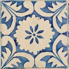 a blue and white tile with an intricate flower design on it's side,