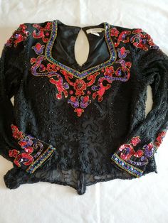 Vintage 60's, I.Magnin Black 100% Silk Beaded Sequined Top Size M (10). Lining Has Been Modified/ Shortened To Have A Younger/ Peek A Boo Look. See Last Photo. Beautiful Top, Full Back Zipper, Provocative Neckline, Sheer Sleeves, Cuff Snaps & Hook & Eye Back Closure In Addition To Zipper. Item Is Pre-Owned. Pet & Smoke Free Home.  Shipped With USPS Priority Mail. Spring Formal Beaded Tops, Long Sleeve Beaded Party Tops, Glamorous Fitted Embroidered Blouse, Fitted Embroidered Tops For Evening, Glamorous Fitted Beaded Tops, Vintage Embellished Tops For Night Out, Vintage Formal Top With Sequins, Vintage Formal Tops With Sequins, Vintage Embroidered Blouse For Party