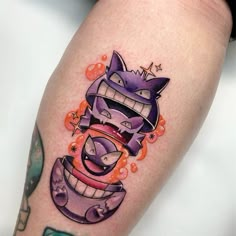 a tattoo on the leg of a person with an evil looking cat in it's mouth