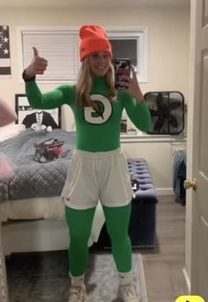 a woman in green and white outfit taking a selfie