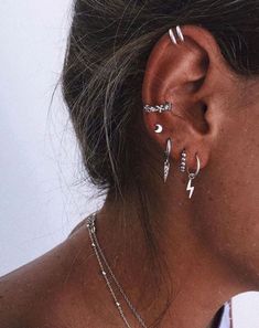 a woman with three ear piercings on her left side and one behind the ear