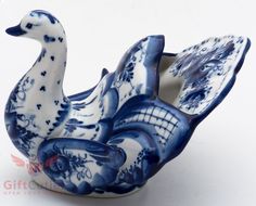 a blue and white porcelain duck sitting on top of it's back legs in front of a white background