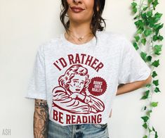 Hey book lover, show off your love for Reading with our retro I'd rather be reading Shirt. The perfect Bookish sweatshirt for Fantasy Readers, Bookworms, Romance Book Lovers, Librarians, Book Nerds and Book club members All designs are available on tshirts/sweatshirts/hoodies. Send me a message if you can't find the product you need! MATERIAL This t-shirt is everything you've dreamed of and more. It feels soft and lightweight, with the right amount of stretch. It's comfortable and flattering for Bookish Tshirt, Reading Tshirt, Hipster Tshirts, T Shirt Png, Reading Shirts, Book Addict, Trendy Tshirts, Cute Tshirts, Apparel Design