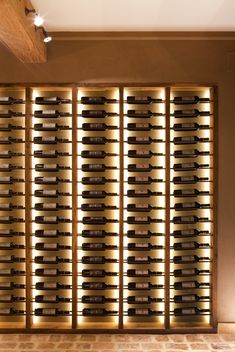 a wine cellar with several rows of bottles on the wall