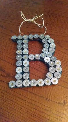 the letter b made out of batteries is hanging on a wooden table with a string attached to it