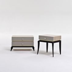 two small tables with drawers on each side, one is grey and the other is black