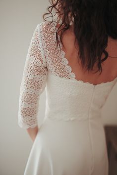 the back of a woman's wedding dress, with her hands on her hips