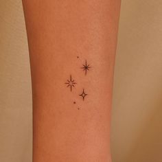 a small star tattoo on the left side of the leg, with three smaller stars behind it