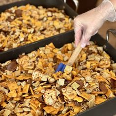 a person holding a brush over a tray full of cheetos and crackers