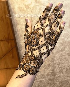 a woman's hand is decorated with hennap and floral designs on it