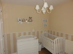 a baby's room with a crib, dresser and lamp hanging from the ceiling