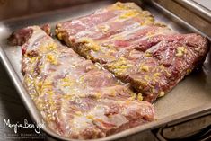 two pieces of raw meat in a metal pan