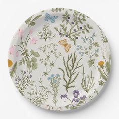 a white plate with colorful flowers and butterflies on the front, against a white background