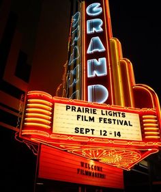 the marquee for the grand theatre is lit up at night