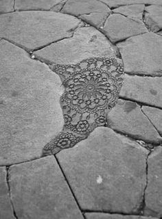 a black and white photo of a stone walkway with an intricate design on the ground