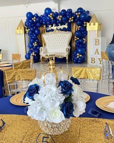 blue and white flowers are in a vase on a table with gold chargers around it