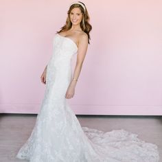 a woman in a white wedding dress posing for the camera with her hand on her hip