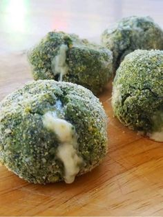 broccoli covered in cheese sitting on top of a wooden cutting board