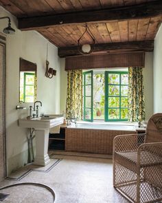 a bathroom with a tub, sink and large window in it's center area