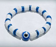 This white blue and black evil eye bracelet is  is perfect for any occasion, it's handmade, carefully crafted and tested to ensure you that it will not break. it is very durable, stretchy and waterproof, the stretch feature provides an easy slip on bracelet so that you don't have to go through the hassle of clipping, and unclipping it. Lastly it's topped off with a evil eye charm. This bracelet is meant to keep away negative energy and spirits because of the evil eye. Its meant to captures this Evil Eye Clay Bead Bracelet, Evil Eye Clay, Black Evil Eye Bracelet, Eye Clay, Clay Beaded Bracelet, Black Evil Eye, White Evil Eye, Pink Heart Necklace, Clay Bead Necklace