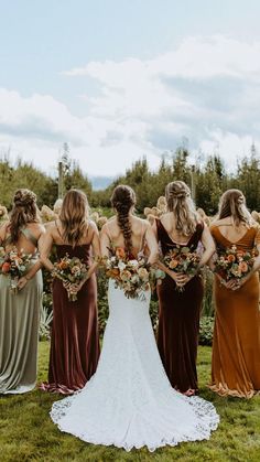 a group of women standing next to each other on top of a lush green field