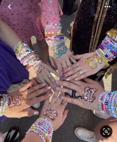 a group of people with their hands covered in bracelets and numbers on their arms