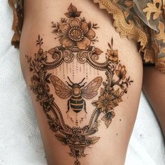 a woman's thigh with a bee and flowers on it