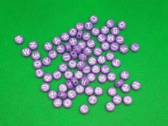 purple and white letters are scattered on a green surface